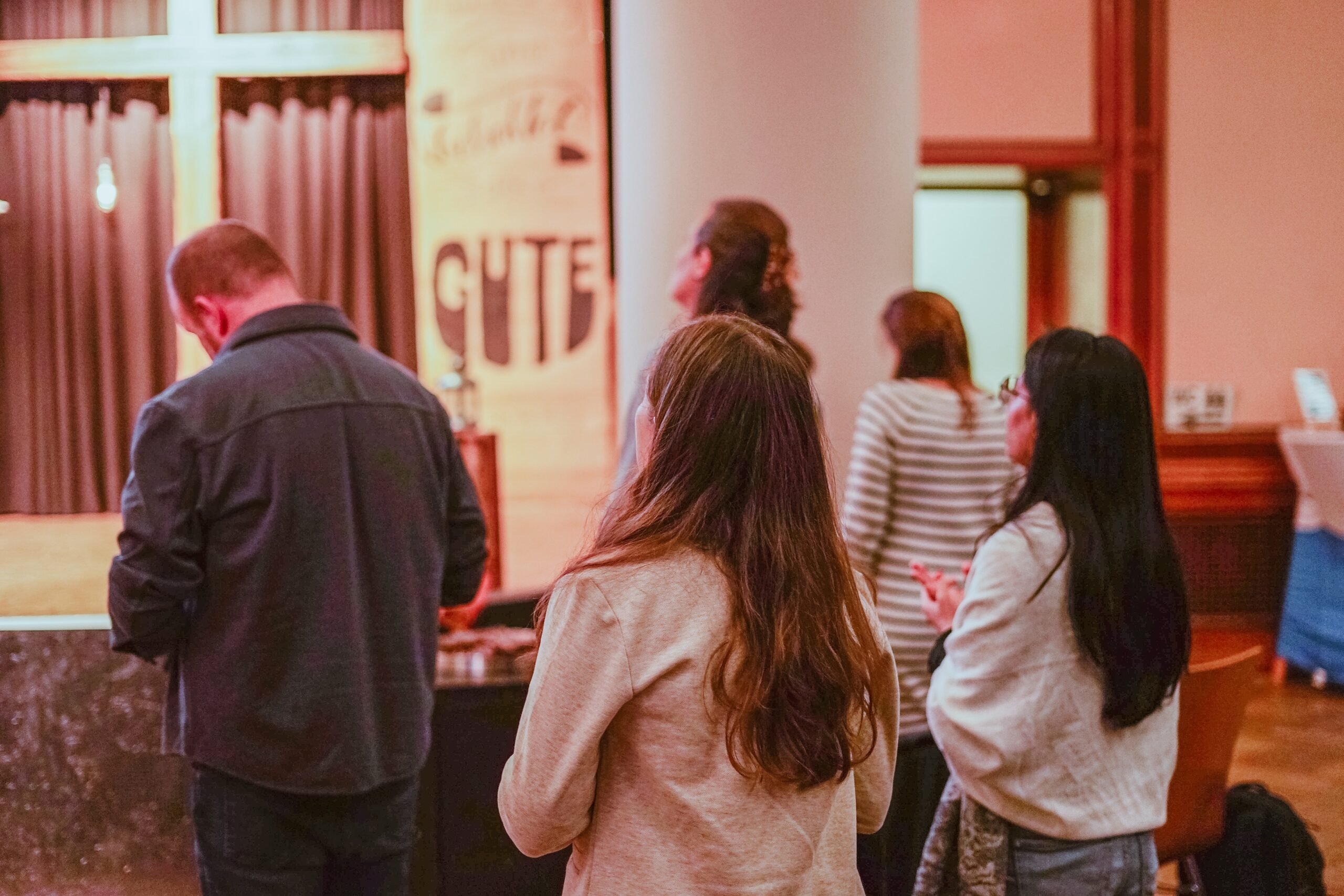 People standing in the hall during worship, seen from behind